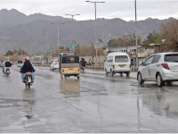 commuters make their way on a road amid rain showers in quetta on thursday photo ppi