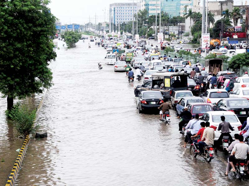 heavy rain on saturday morning flooded the road leading to kalma chowk near barkat market l a rickshaw driver pushes the vehicle through water standing on abbot road photo express