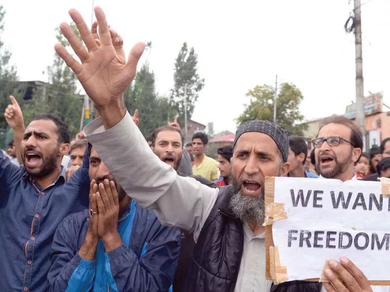 a kashmiri protester holds a placard as others chant slogans during a protest in srinagar photo afp a kashmiri protester holds a placard as others chant slogans during a protest in srinagar photo afp