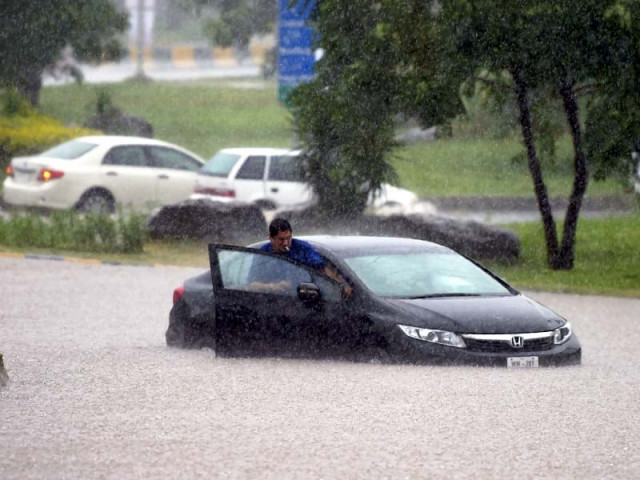 a commuter tries to move his car through floodwaters during heavy rain in islamabad on saturday photo afp a commuter tries to move his car through floodwaters during heavy rain in islamabad on saturday photo afp