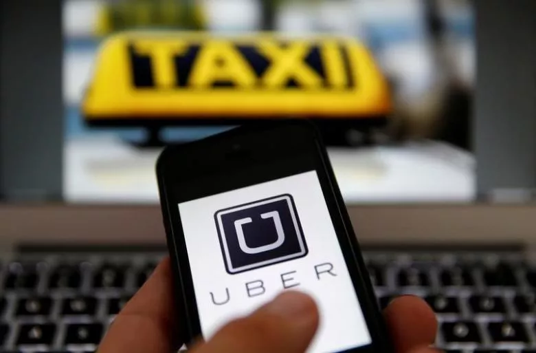 an illustration picture shows the logo of car sharing service app uber on a smartphone next to the picture of an official german taxi sign september 15 2014 photo reuters an illustration picture shows the logo of car sharing service app uber on a smartphone next to the picture of an official german taxi sign september 15 2014 photo reuters