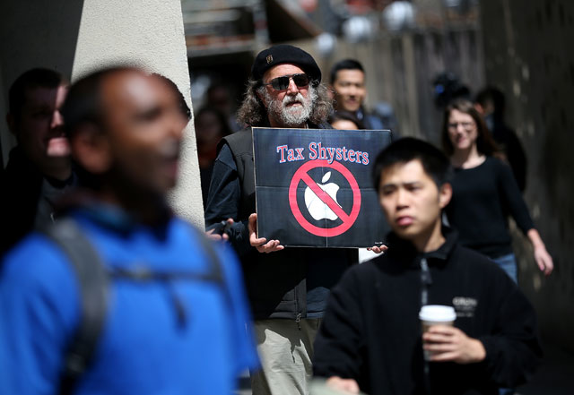 this file photo taken on april 15 2014 shows a protester holding a sign during a demonstration outside of an apple store on april 15 2014 in san francisco california photo afp