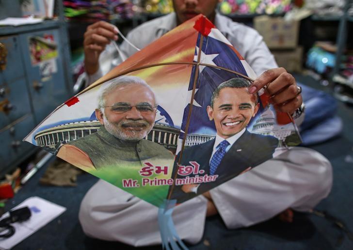 an employee ties threads on a kite with portraits of indian prime minister narendra modi l and us president barack obama ahead of obama 039 s visit in mumbai photo reuters