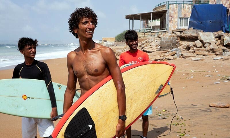 attiq ur rehman 21 walks with his teammates along the beach as they prepare to surf at turtle beach in karachi pakistan september 4 2024 reuters