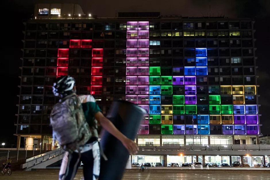 an israeli cyclist plays against foreign visitors in a giant tetris tournament illuminating the windows of the facade of the tel aviv yafo municipality building photo afp