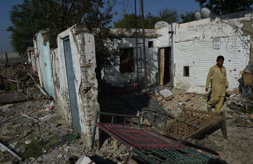 pakistani christian walks past a damaged house in a christian colony on the outskirts of peshawar on september 3 2016 a day after security forces killed four suicide bombers photo afp