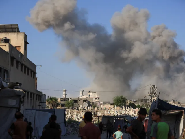 Palestinians look on as smoke rises following an explosion during an Israeli operation in Gaza City, August 26 [Reuters]