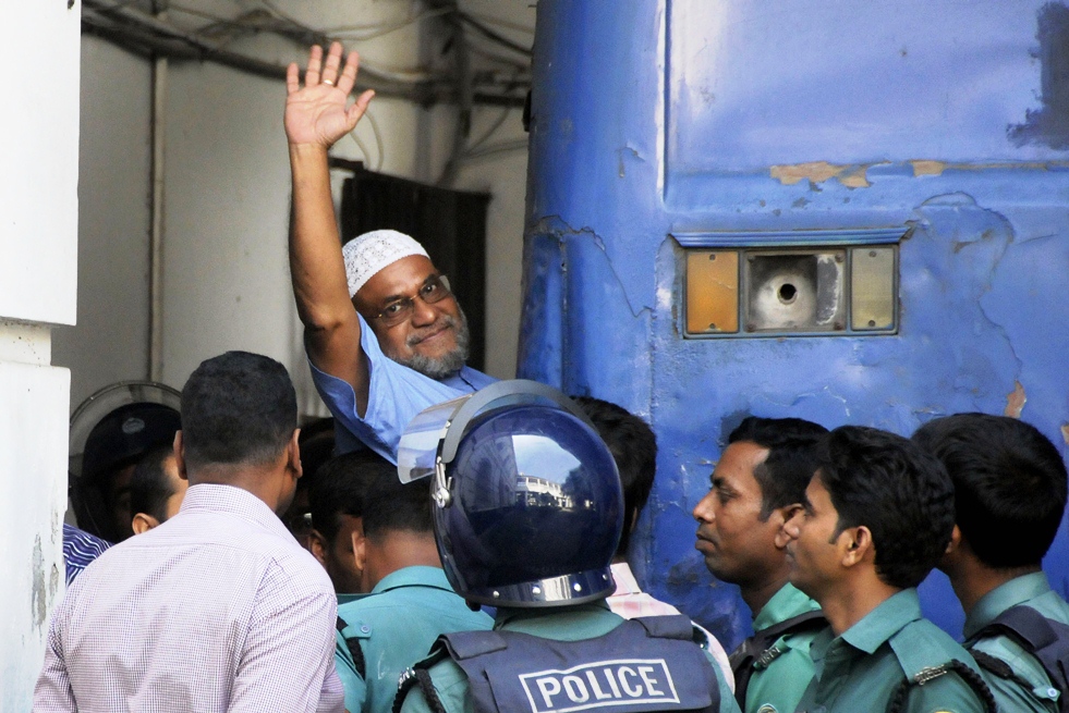 jamaat e islami party leader mir quasem ali waves his hand as he enters a van at the international crimes tribunal court in dhaka on november 2 2014 photo afp