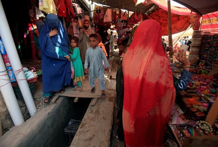 An Afghan woman, clad in a burqa, shops at a market in Peshawar, Pakistan June 29, 2016. PHOTO: REUTERS