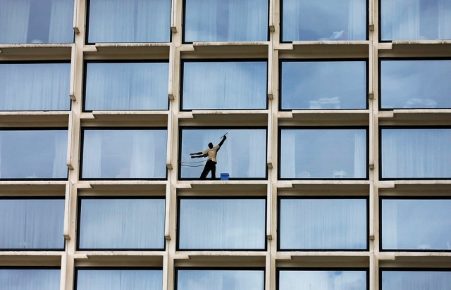 a worker cleans the windows of a luxury hotel in colombo sri lanka photo reuters