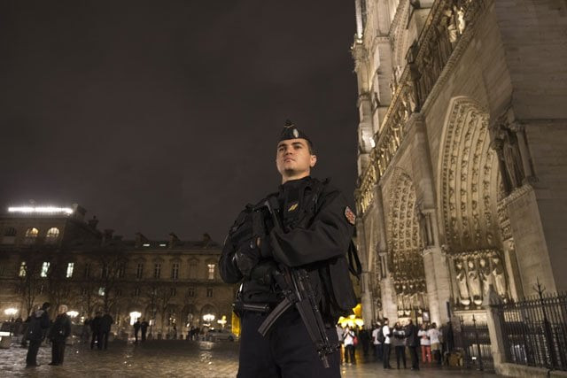 a police man on guard outside notre dame cathedral in the centre of paris photo afp