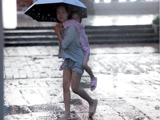 extreme weather a person carries a child while walking with an umbrella as rain intensifies ahead of the arrival of typhoon bavi in wenzhou china photo reuters extreme weather a person carries a child while walking with an umbrella as rain intensifies ahead of the arrival of typhoon bavi in wenzhou china photo reuters