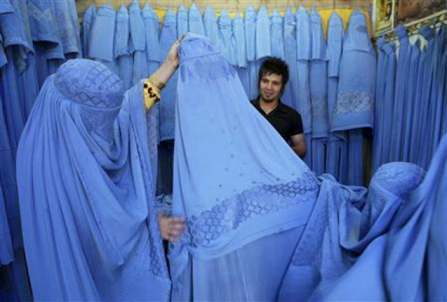 an afghan woman looks at merchandise at a burqa shop in herat in western afghanistan july 2 2009 photo reuters