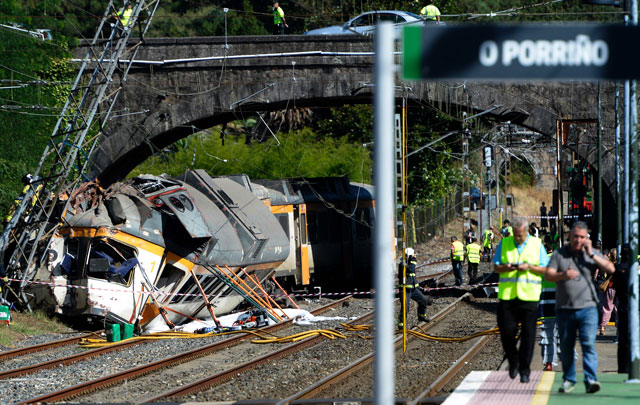 firefighters and rescuers inspect the wreckage of a train derailed in o porrino northwestern spain leaving at least four people dead and some 50 injured on september 9 2016 photo afp