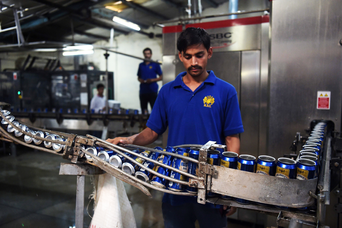 pakistani worker checks a line of beer cans at the muree brewery company in rawalpindi photo afp