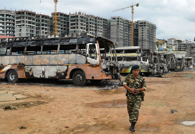 a security personnel walks past the skeletal remains of karnataka state transport buses following violence due to the cauvery water dispute in bangalore on september 13 2016 photo afp