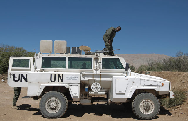 a peacekeeper of the united nations disengagement observer force undof stands on a vehicle as he monitors the border with syria near the village of majdal shams in the israeli occupied sector of the golan heights on september 13 2016 photo afp