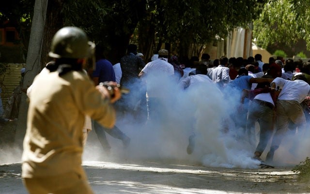 protesters run away as a policeman fires tear gas towards them during a protest against the recent killings in kashmir on the outskirts of srinagar august 5 2016 reuters danish ismail