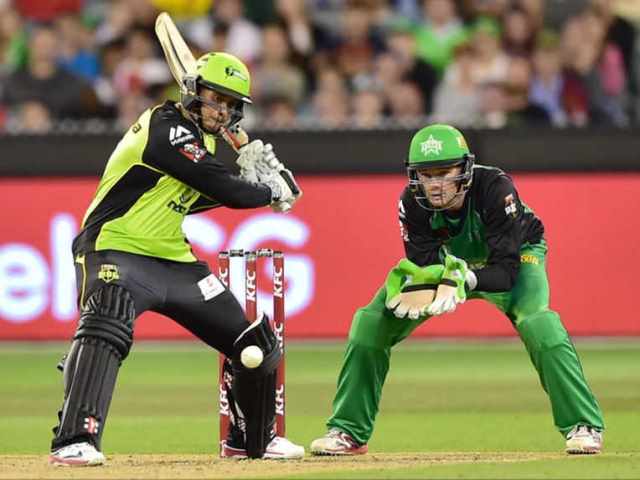 sydney thunder cricketer usman khawaja left plays a shot as melbourne star wicketkeeper peter handscomb right looks on during the t20 big bash league final at the melbourne cricket ground photo afp