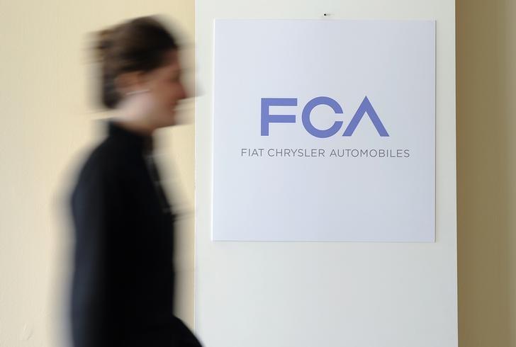 a woman walks past a logo of fiat chrysler automobiles fca in turin march 31 2014 photo reuters