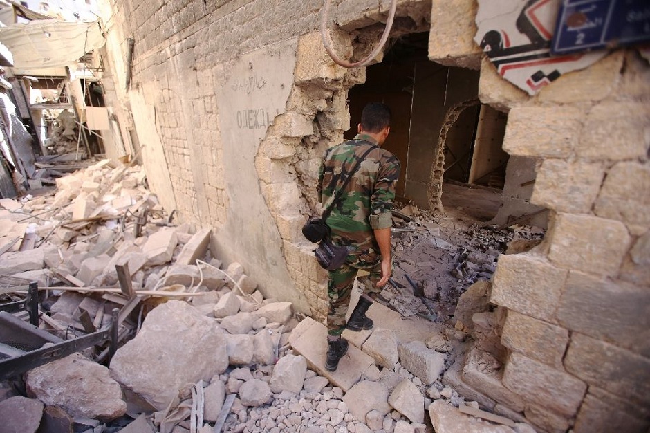 a syrian soldier walks through the war damaged al farafira souk in aleppo 039 s historic city centre photo afp