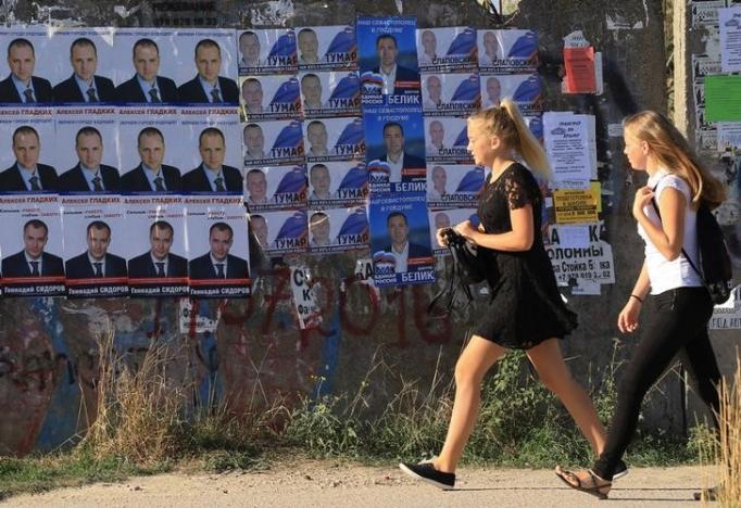 girls walk past election campaign posters of candidates running for deputies ahead of september 18 parliamentary elections in the black sea port of sevastopol crimea september 16 2016 photo reuters