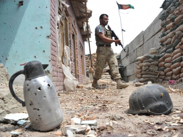 an afghan security serviceman keep watch at a damaged police post following an airstrike in bati kot district in nangarhar province on august 1 2013 photo afp