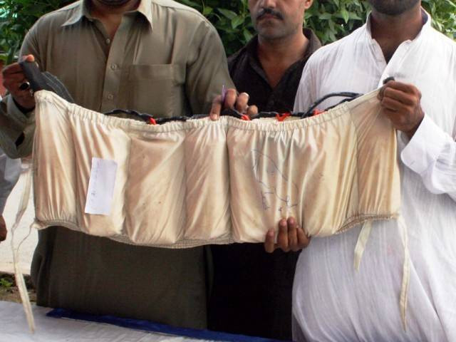 police officials hold a suicide jacket in their hands photo express news police officials hold a suicide jacket in their hands photo express news