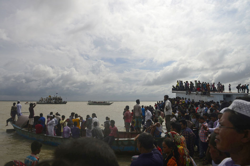 bangladeshi onlookers gather near the scene where an overloaded ferry capsized in the padma river in munshiganj some 30 kilometres 20 miles south of the capital dhaka on august 4 2014 photo afp