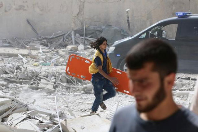 a man runs with a stretcher in a damaged site after airstrikes on the rebel held al qaterji neighbourhood of aleppo syria september 21 2016 photo reuters