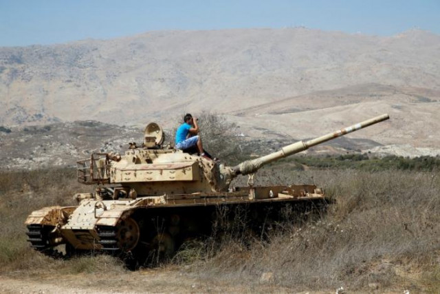 a man sits on an old tank as he watches fighting taking place in syria as seen from the israeli side of the border fence between syria and the israeli occupied golan heights september 11 2016 photo reuters a man sits on an old tank as he watches fighting taking place in syria as seen from the israeli side of the border fence between syria and the israeli occupied golan heights september 11 2016 photo reuters
