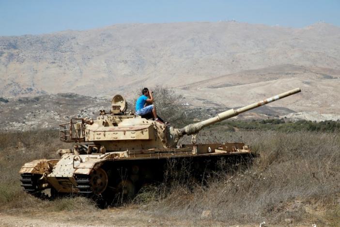 a man sits on an old tank as he watches fighting taking place in syria as seen from the israeli side of the border fence between syria and the israeli occupied golan heights september 11 2016 photo reuters