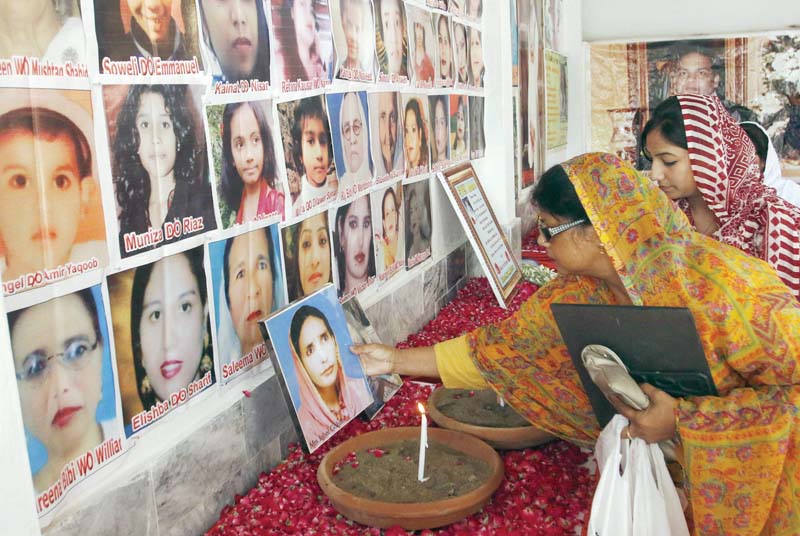 a woman holds a picture of one of the kohati church blast victims photo muhammad iqbal express