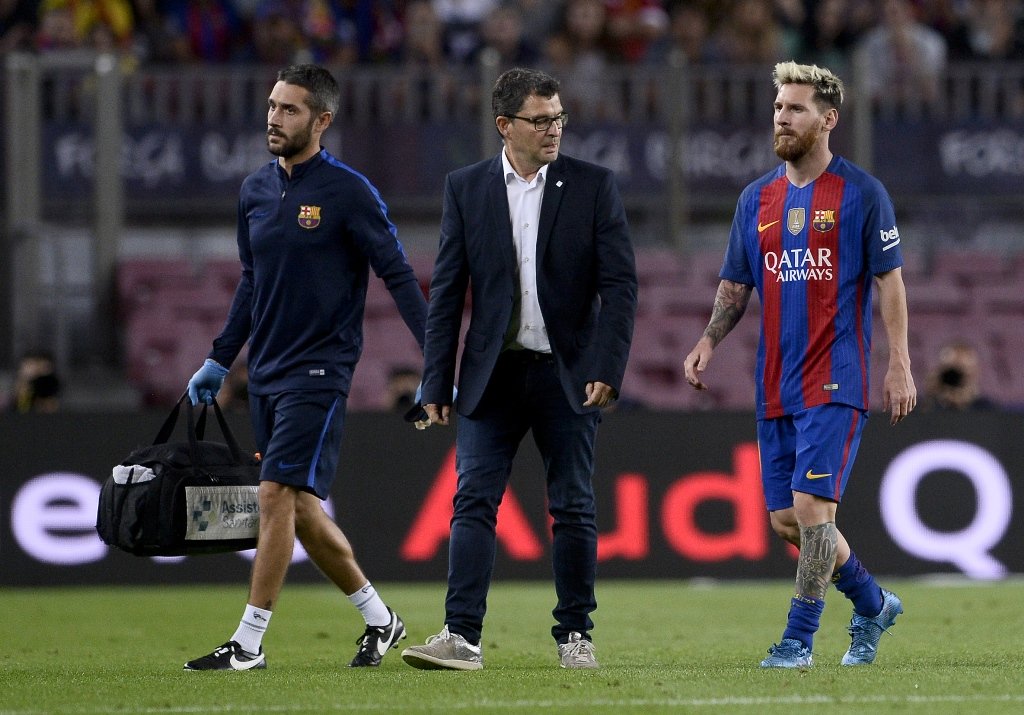 lionel messi r leaves the pitch with the team 039 s doctor at the camp nou stadium in barcelona on september 21 2016 photo afp