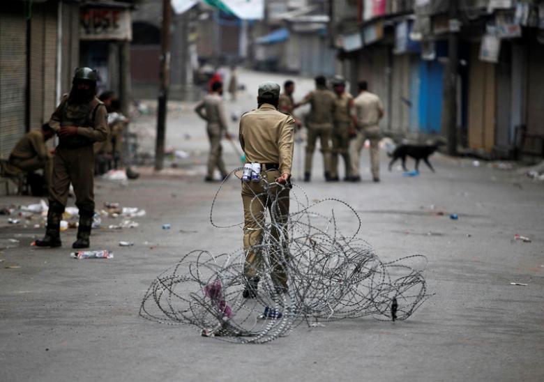 an indian policeman pulls concertina wire to lay a barricade on a road during a curfew in srinagar july 12 2016 photo reuters