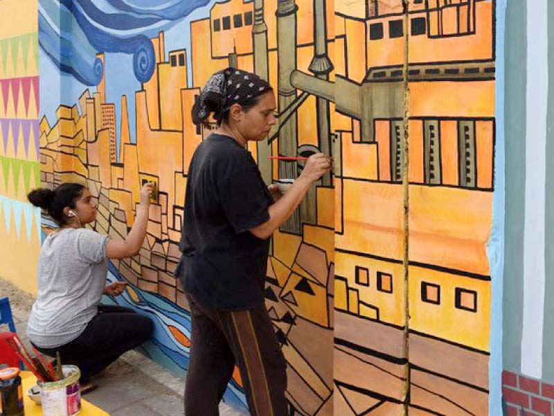 art teacher nooryya shaikh nabi right and her daughter gaiti ara rendering final touches to a design on a wall in karachi photo file