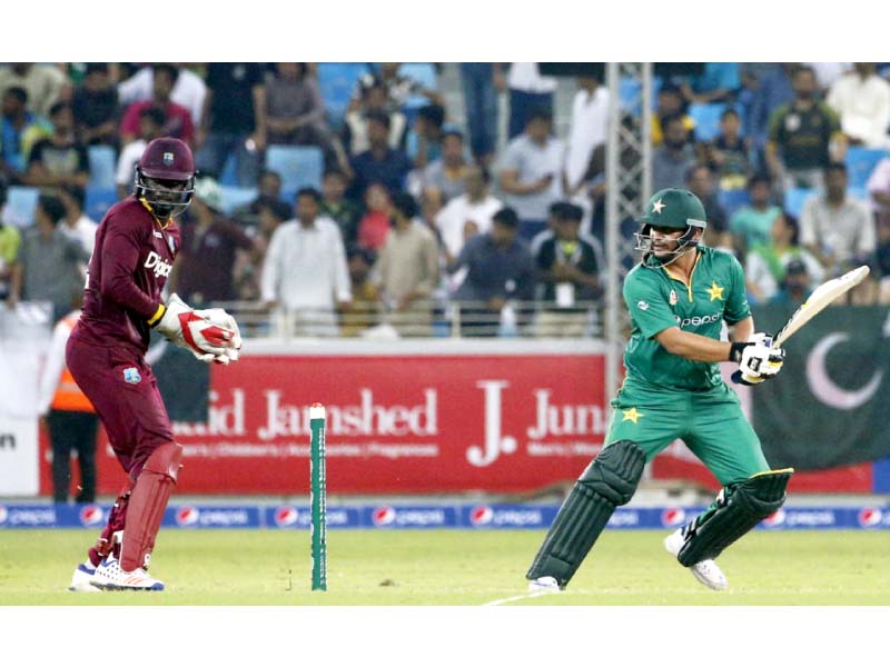 khalid latif and west indies wicketkeeper watch the ball during the first t20i match in dubai photo afp