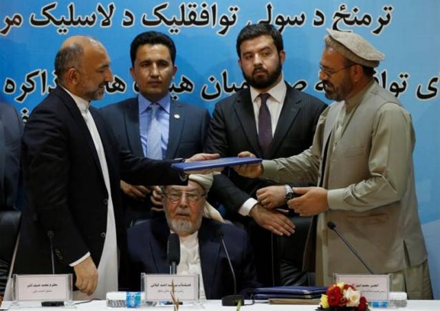 mohammad amin karim r representative of gulbuddin hekmatyar and afghanistan national security adviser mohammad hanif atmar l hold a document after signing a peace deal in kabul photo reuters