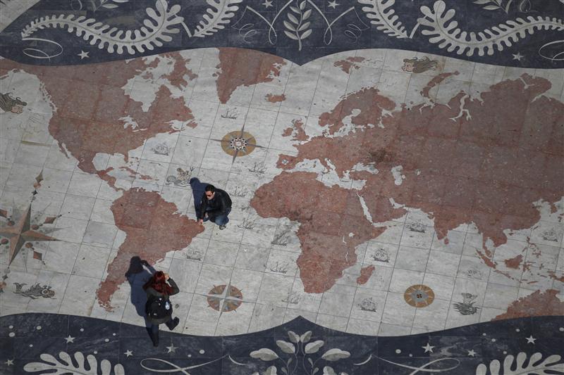a man is photographed on a square decorated with a giant world map photo reuters