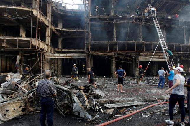 people gather at the site of a suicide car bomb in the karrada shopping area in baghdad iraq july 3 2016 photo reuters