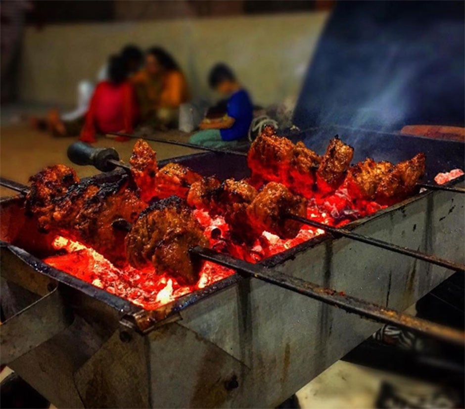 skewered meat being grilled at a barbecue in karachi photo aly hamzu