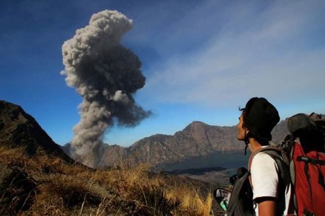 a hiker looks at mount barujari on lombok island in indonesia as it spews volcanic ash in november 2015 photo afp