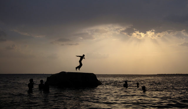 a boy prepares to jump off a rock into the waters of the osman sagar lake near the southern indian city of hyderabad may 29 2011 photo reuters