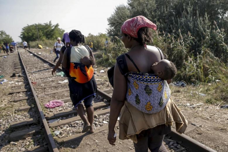 migrants hoping to cross into hungary walk with babies on their backs along a railway track outside the village of horgos in serbia towards the border it shares with hungary photo reuters