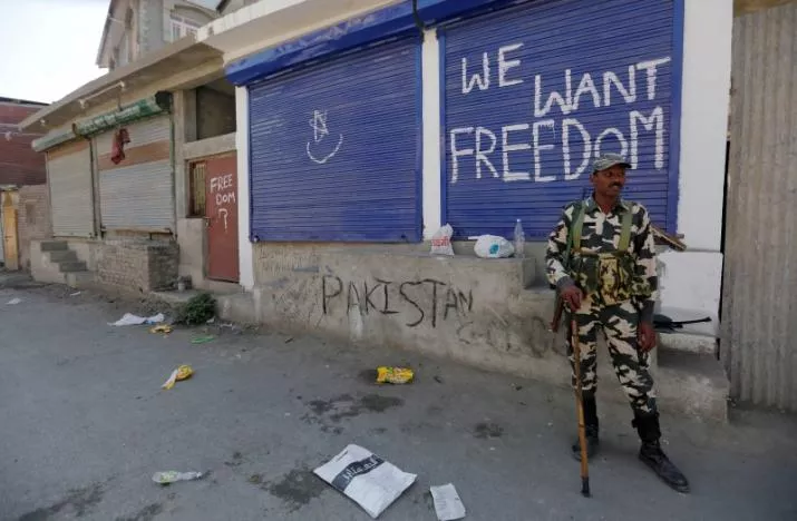 an indian policeman stands guard near shops painted with graffiti during a curfew in srinagar august 5 2016 photo reuters an indian policeman stands guard near shops painted with graffiti during a curfew in srinagar august 5 2016 photo reuters