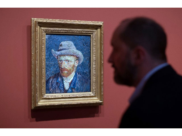 this photo taken on may 13 2016 shows a man looking a vincent van gogh painting entitled self portrait with grey felt hat photo afp