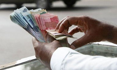 a man counts pakistani rupee pkr notes photo reuters
