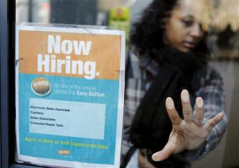a woman opens a glass door with a quot now hiring quot sign on it as she enters a staples store in new york march 3 2011 new u s claims for unemployment benefits fell last week to their lowest level in more than 2 1 2 years signalling an acceleration in job creation could be taking shape photo reuters