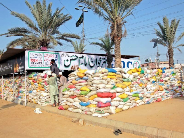 a dastarkhwan set up at numaish chowrangi for the mourners has been secured by a wall of jute bags photo athar khan express