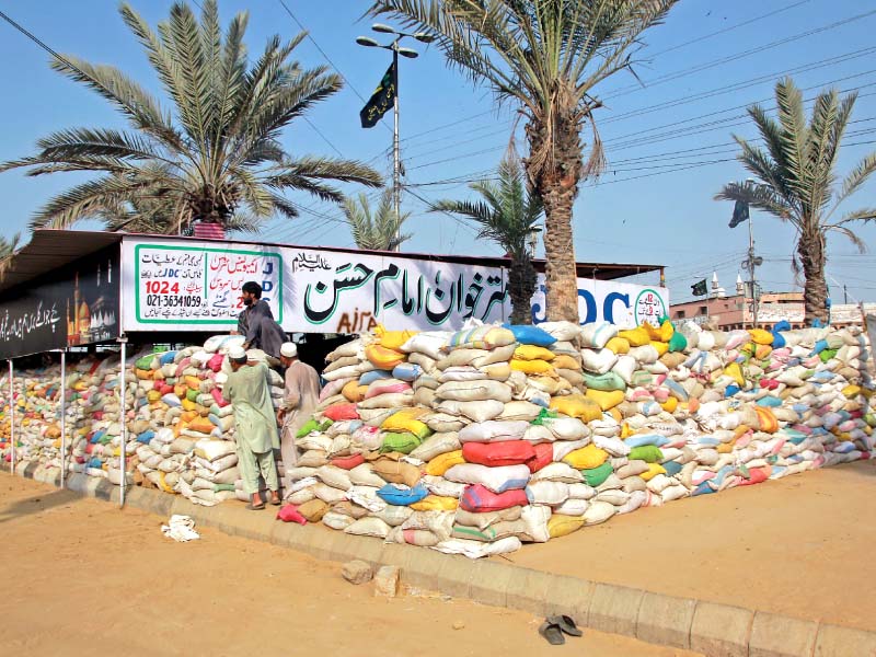 a dastarkhwan set up at numaish chowrangi for the mourners has been secured by a wall of jute bags photo athar khan express